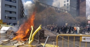 Barricada de foc dels antifeixistes davant dels mossos que els impedeixen acostar-se a l'acte de Vox