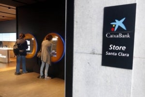 Gironins retirant diners de la sucursal que CaixaBank té al carrer Santa Clara de Girona