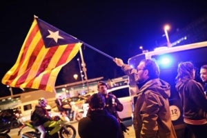 Membres del CDR branden una estelada davant el cordó policial