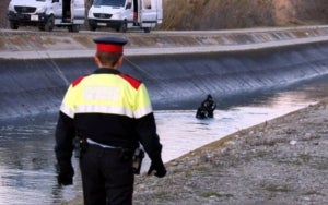 Un mosso caminant pel voral del canal de Seròs i la unitat subaquàtica dins el canal