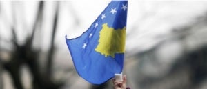 Una nena oneja la bandera de Kosovo a Pr&iacute;stina