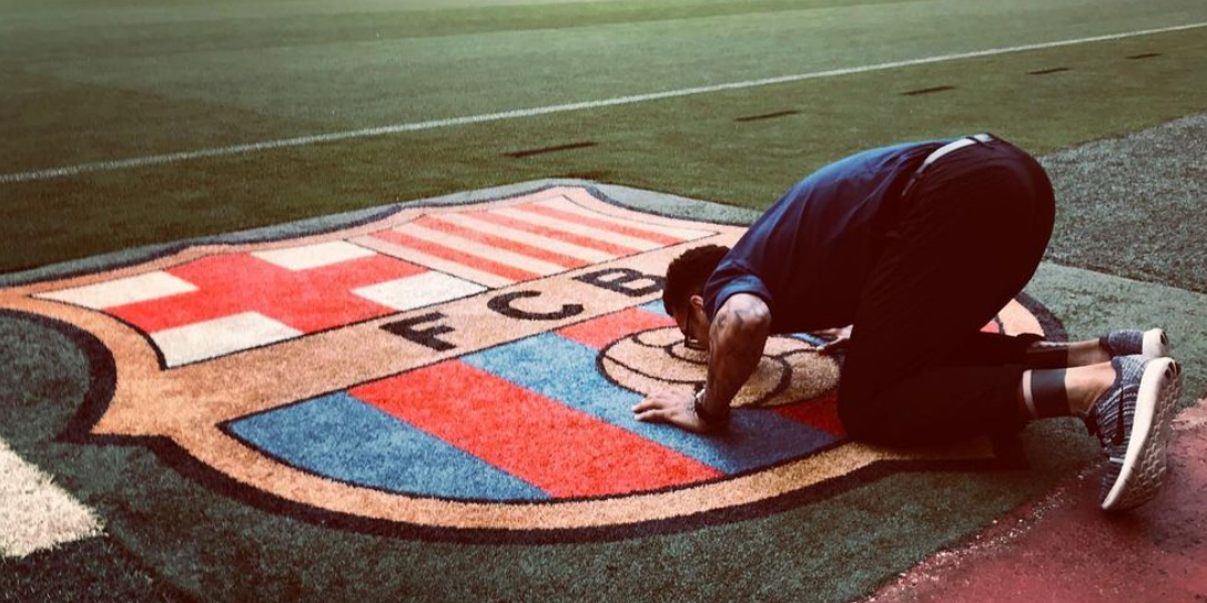 Dani Alves fa un petó a l'escut del Barça que hi ha a la gespa del Camp Nou | Dani Alves