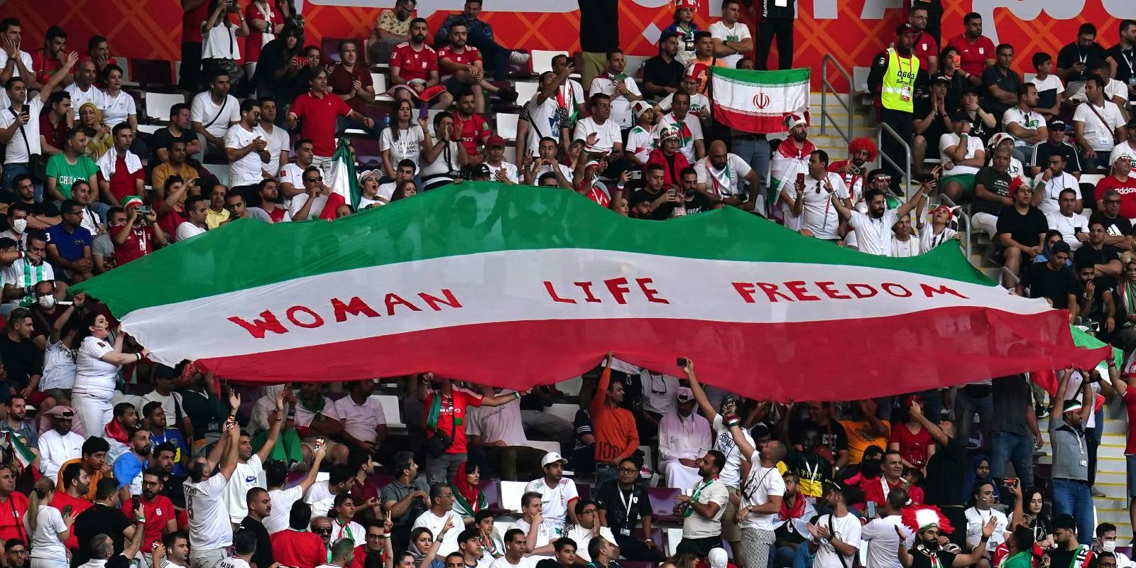 Els aficionats de l'Iran sostenen una bandera iraniana amb les paraules 'Woman Life Freedom' durant el partit del Mundial entre Anglaterra i l'Iran | Europa Press