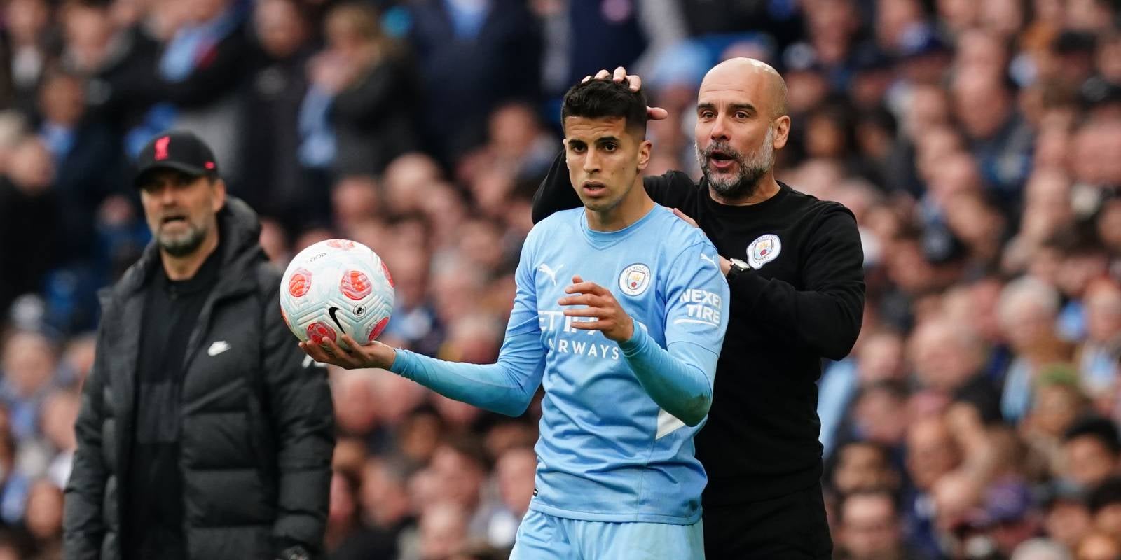 Pep Guardiola i Joao Cancelo, durant un partit entre el Manchester City i el Liverpool de la temporada 2021/2022 | Europa Press