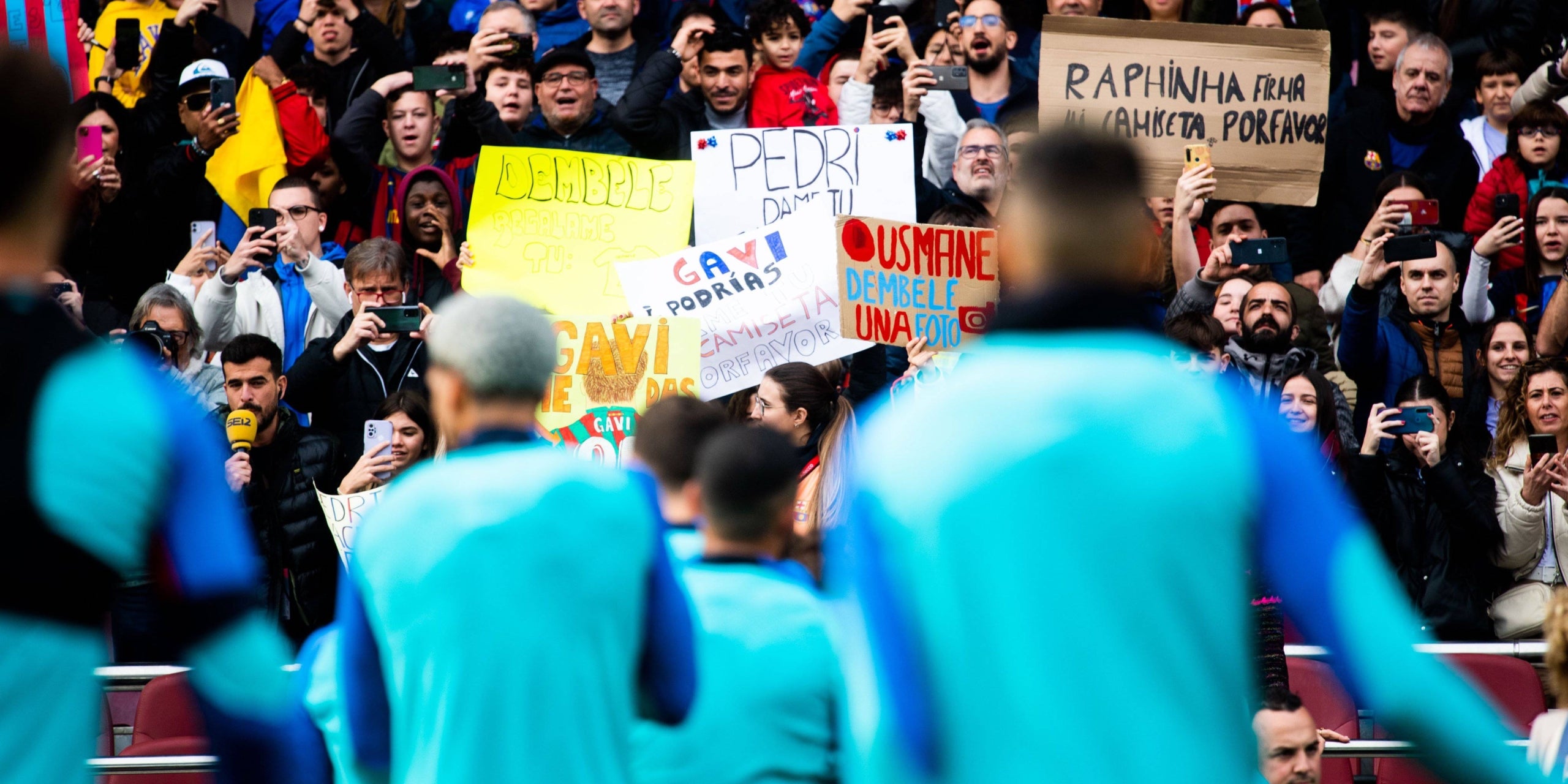Aficionats amb pancartes i cartells a l'entrenament de portes obertes del Barça al Camp Nou | FC Barcelona